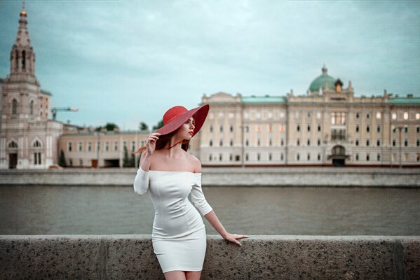 Fille en robe blanche. fille au chapeau rouge. rivière. quai