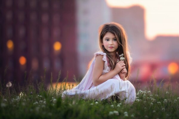 Niña en un claro de flores. Imagen de un ángel