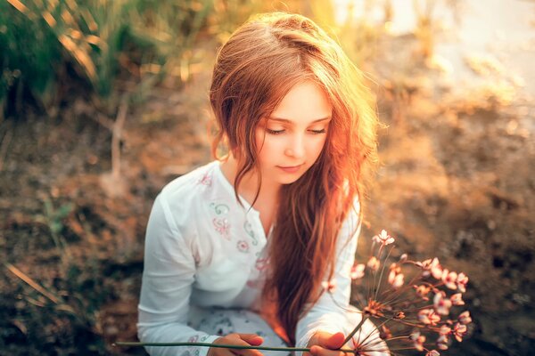 Girl with flowers on the background of the sun