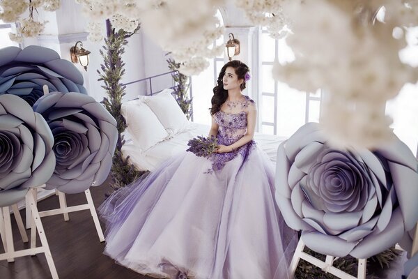 Chica en un vestido de color lavanda en la cama