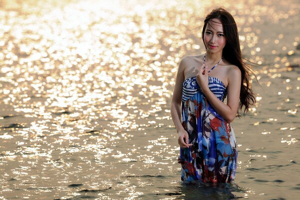 Ragazza asiatica in piedi nel mare