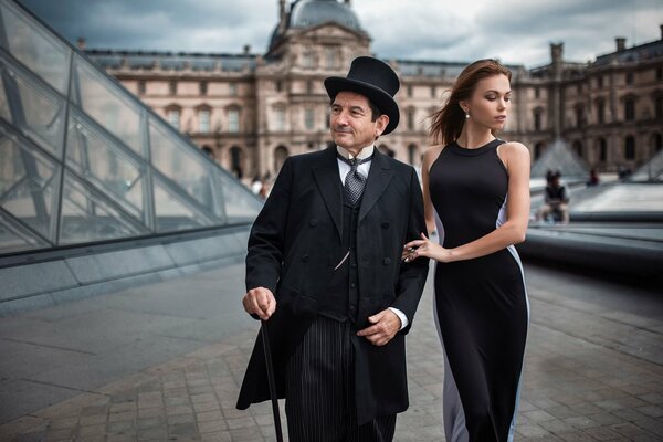 Coppia interessante: un uomo di età e una giovane ragazza passeggiando per una strada a Parigi