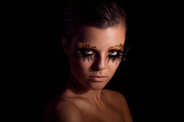 Retrato de una chica con maquillaje sobre un fondo negro