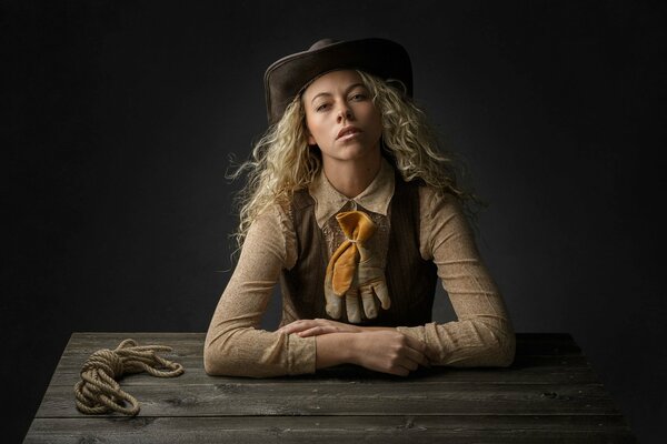 Blonde girl in a cowboy hat at the table