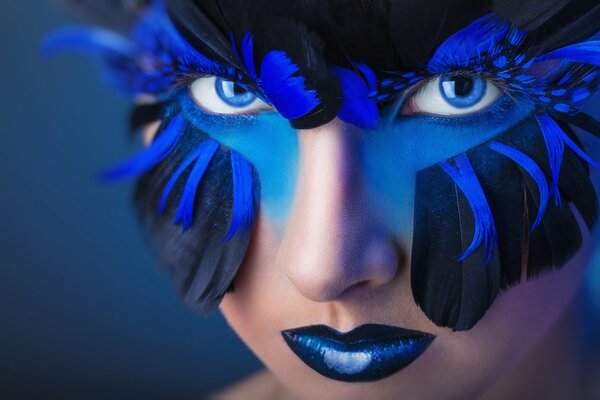 A girl with a mask on her face made of feathers