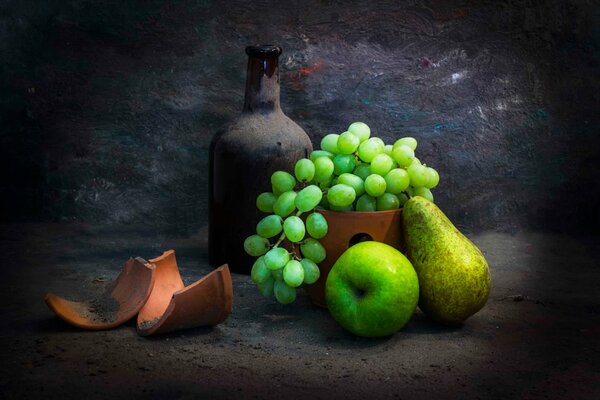 Fruits and an antique bottle on a dark background