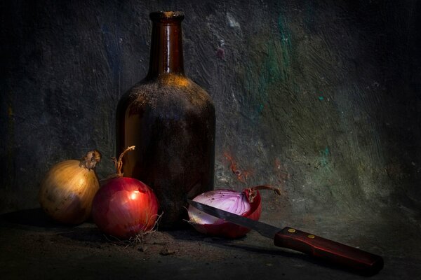 Zwiebel und Messer neben der Flasche