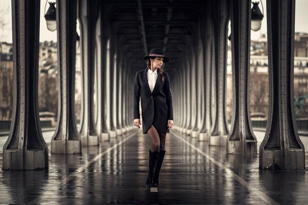 A girl in a hat walks along the station square
