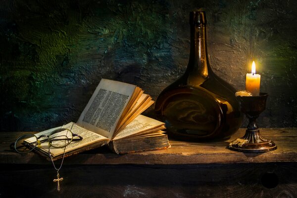 A book with a cross and a candle on the table