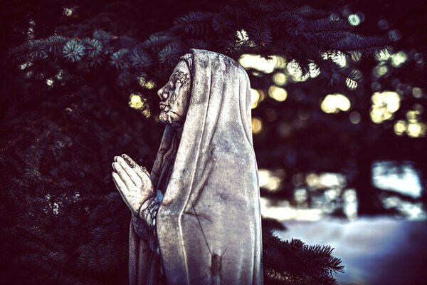 An old statue of a girl who prays