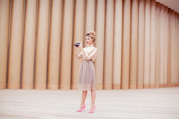 Dziewczyna z aparatem w sukience i różowych butach