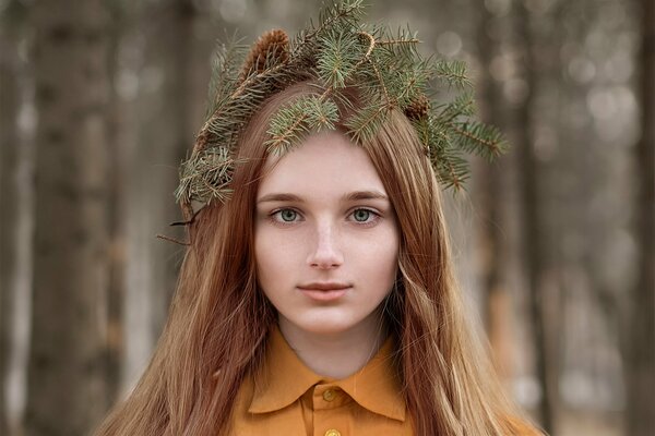 Encantadora pelirroja chica con una corona de conos