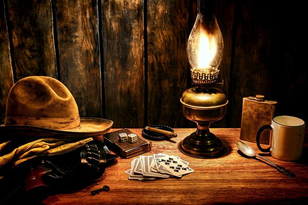Martwa natura z kowbojskim kapeluszem i lampą naftową