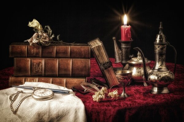 Nature morte de la table avec des horloges, de la vaisselle et des livres aux chandelles