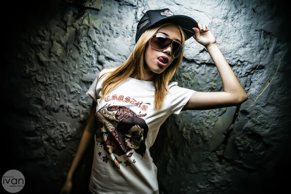 Fille en t-shirt et casquette. Mur