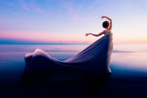 A girl in a flying dress on the horizon background