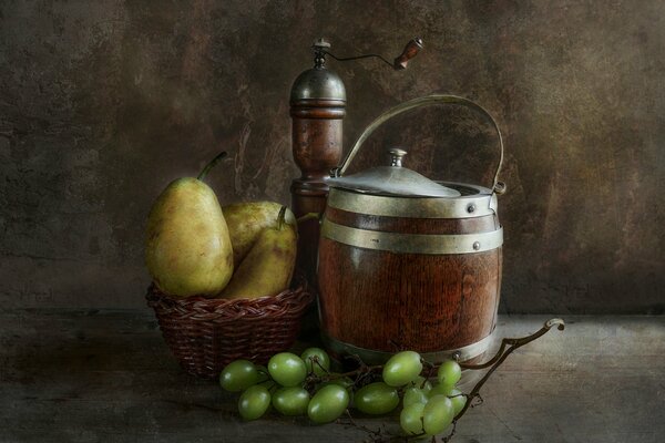 A basket with pears, and next to grapes and a barrel