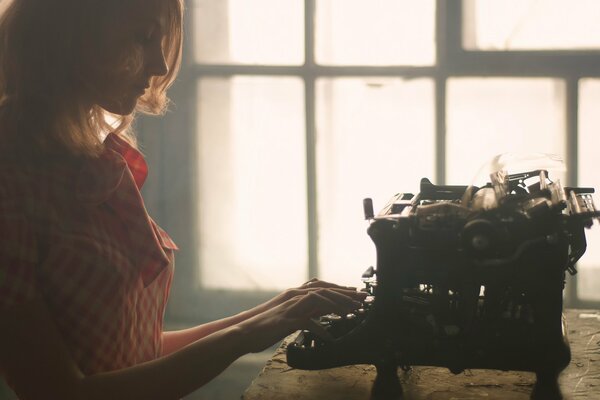 Redhead girl at the typewriter retro