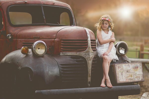 Child model for photography with a car and a suitcase