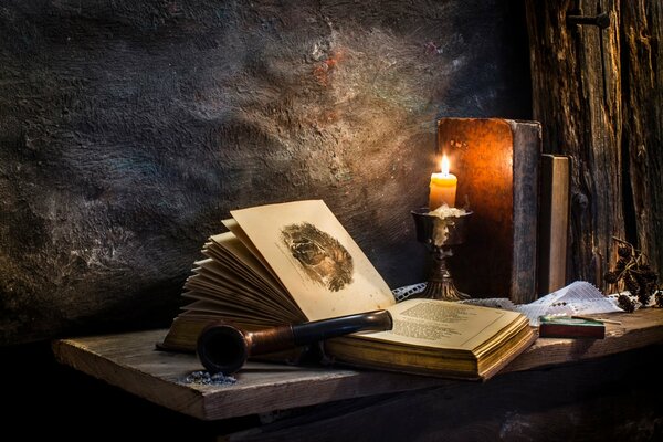 Altes Buch auf dem Tisch bei Kerzenlicht