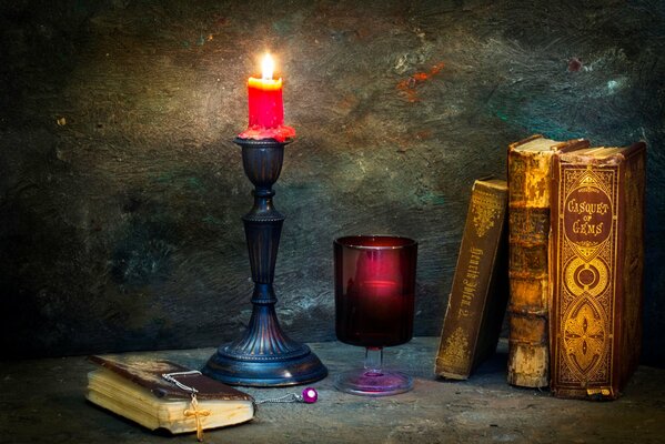 A burning candle. Books. Cross