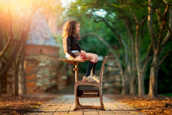 Fille assise sur le bureau dans la rue