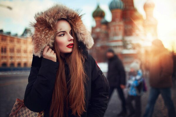 A girl in a jacket with fur on red Square