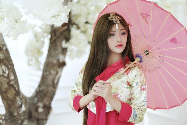 Asian woman posing in the garden with an umbrella