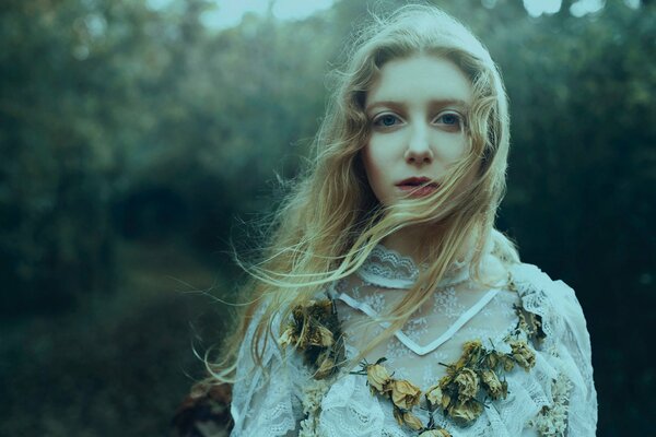 Fille blonde avec des fleurs sèches sur le décolleté