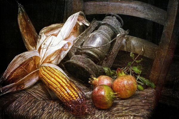 A vintage lamp, corn and pomegranates are lying on a chair