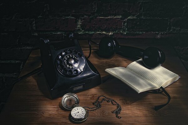 There is a pocket watch on the table by the wall