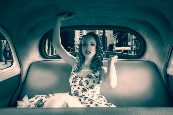 Hermosa chica en un coche retro