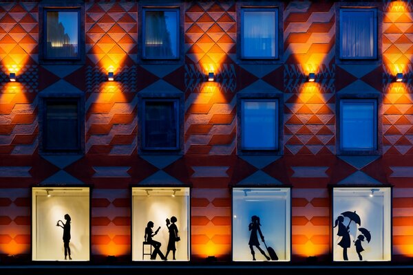 Les fenêtres des maisons et les silhouettes des gens en eux ont chacun leur propre style de ville