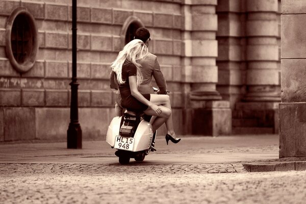 The old streets of Copenhagen. Girl with a guy on a scooter