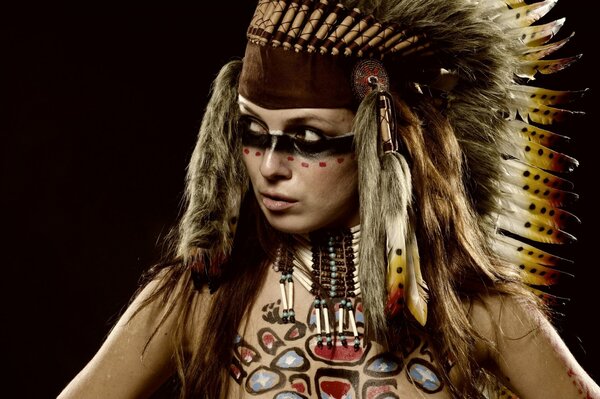 A girl in an Indian war paint with feathers