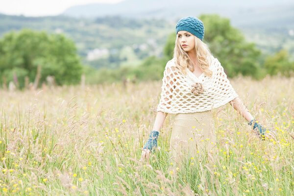 A fashionable girl on the field with a dress and a knitted beret on her head