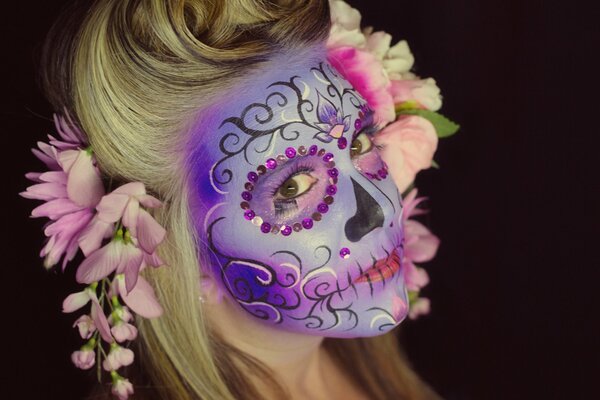 A designer mask on the girl s face. Preparing for the Day of the Dead