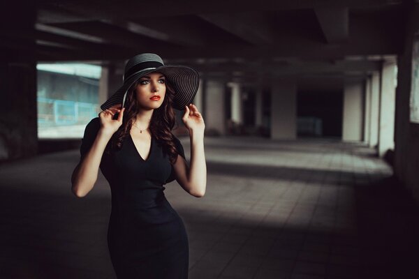 A girl in a hat and a black dress