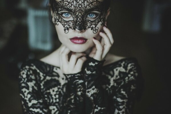 Masquerade mask and black dress on a girl