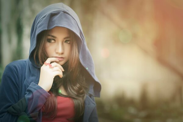 A girl in a hood on a blurred background