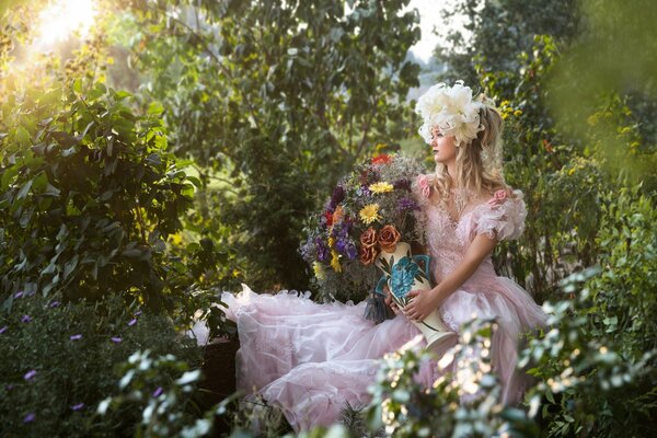 La ragazza si siede sulla natura con i fiori