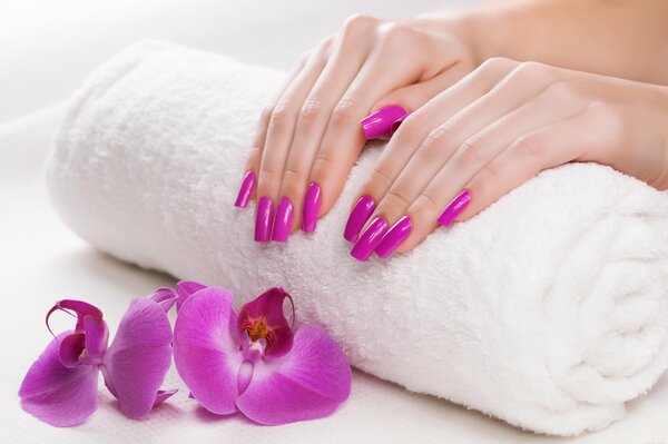 Manicure fresca per il colore dell orchidea su un asciugamano bianco