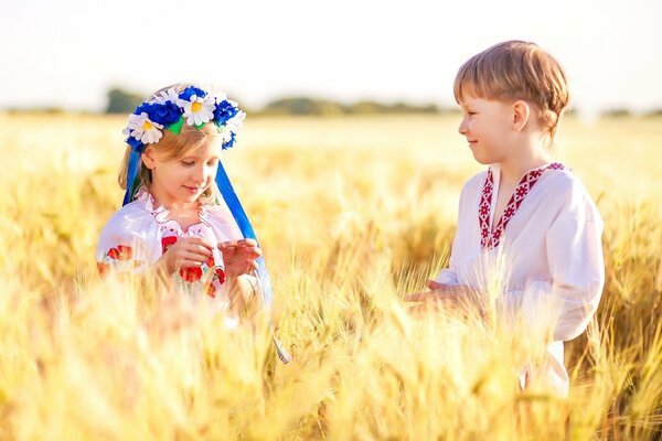 Niños en coronas en un campo de trigo