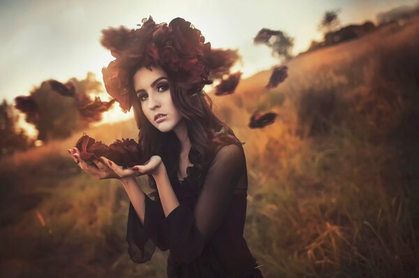 Chica con una escoba de hojas de otoño