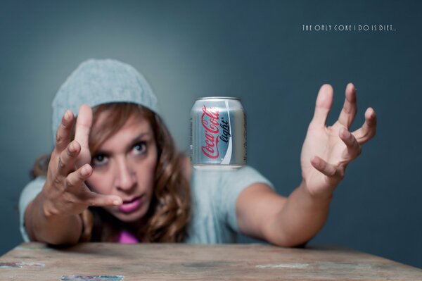 Mädchen fängt eine Dose Cola mit den Händen