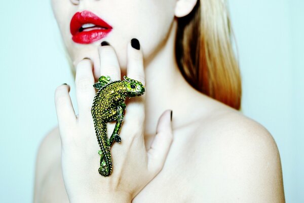 A girl with a ring on her hand in the form of a chameleon