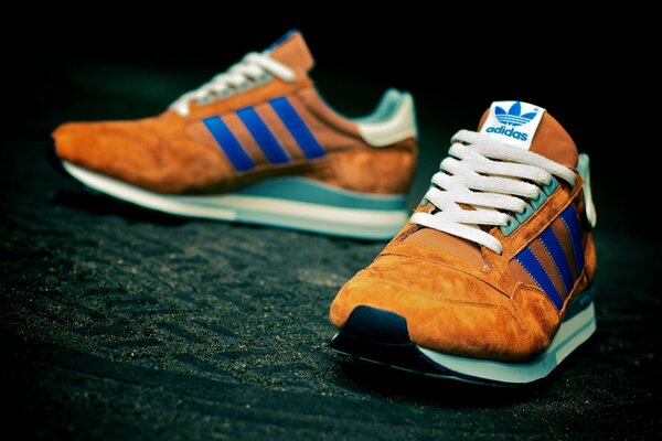 Sneakers Adidas arancioni con strisce blu