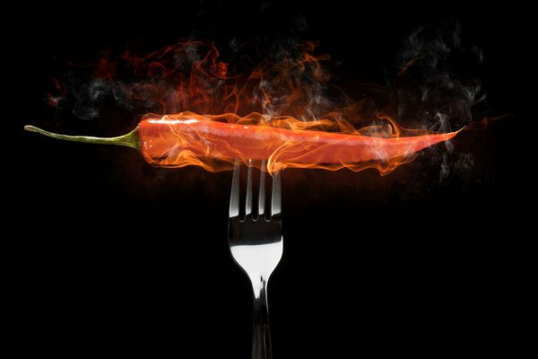 Burning chili pepper impaled on a fork