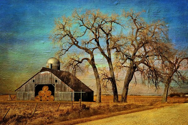 A barn with hay standing near the road