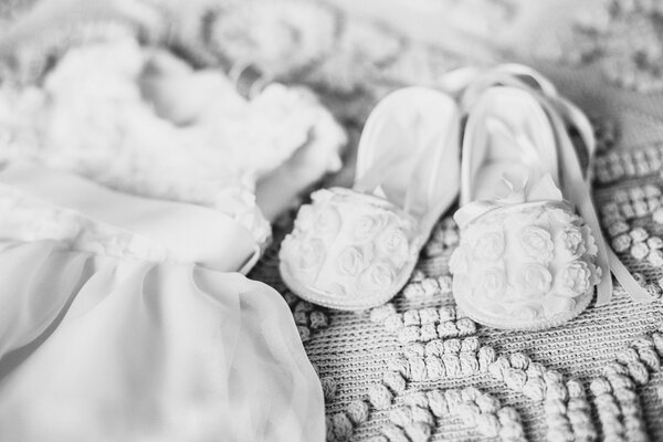 Foto en blanco y negro. Vestido y zapatos de bebé